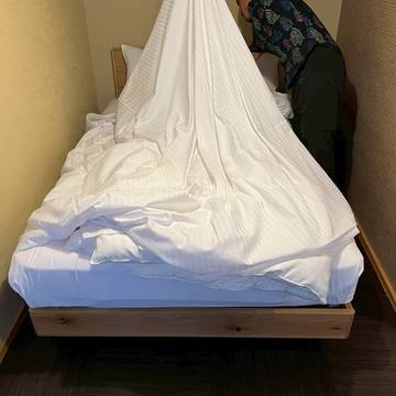 シーツを広げるスタッフ