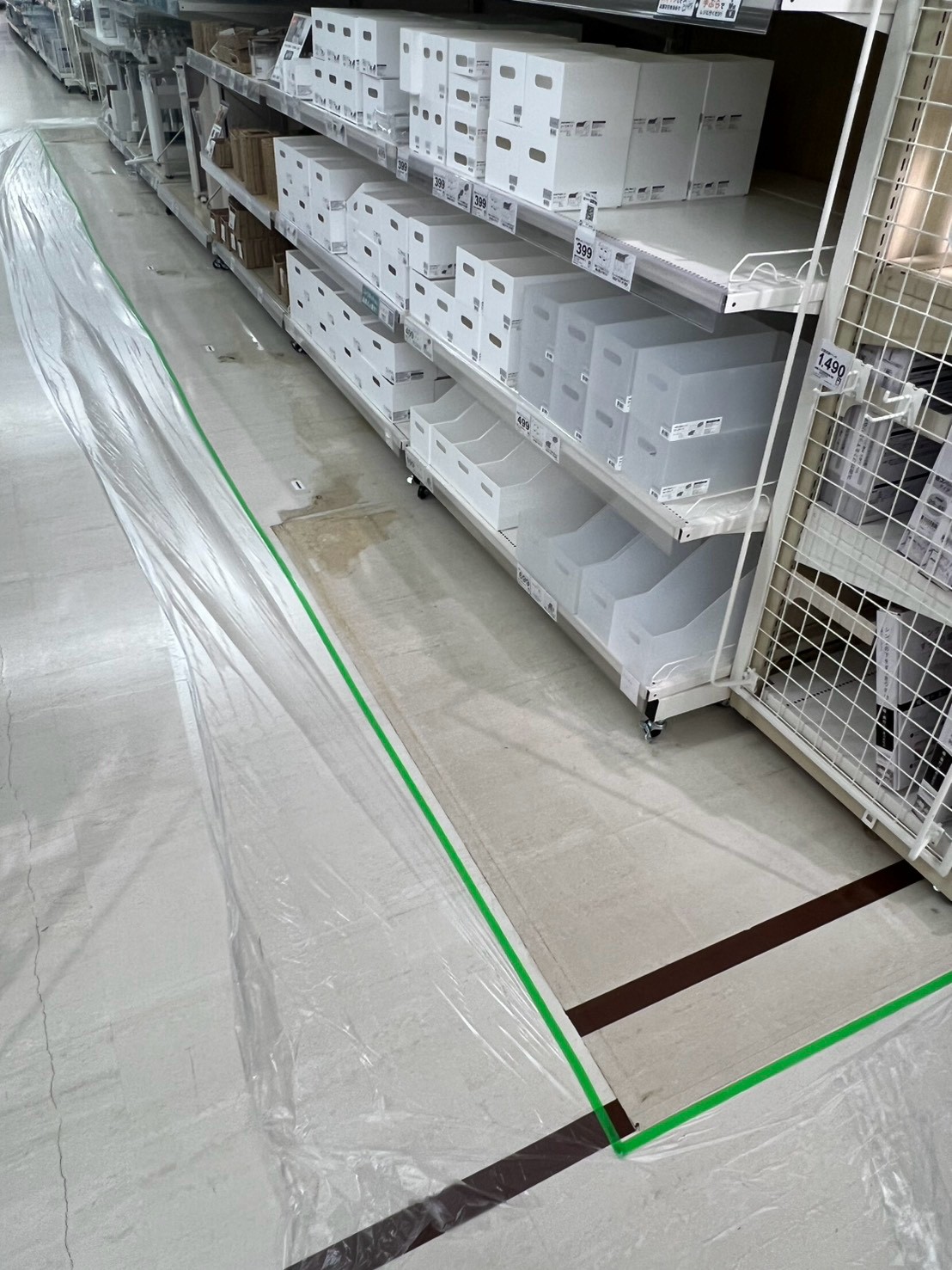 家具店の床面剥離作業で保護シートとテープを敷いた通路の現場写真